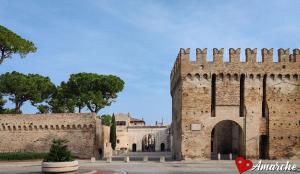 ein altes Backsteingebäude mit einem Torbogen in einem Innenhof in der Unterkunft La Casetta del Marinaio in Fano