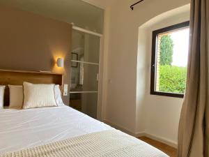 a bedroom with a white bed and a window at Casa Olímpia in Monells