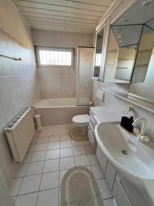a bathroom with a sink and a tub and a toilet at Villa Altdorf in Ettenheim +29 photos