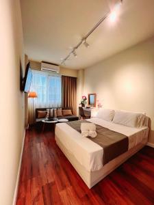 a bedroom with a large bed and a living room at 70 steps studio A, 50 meters from Dimokratias metro station in Thessaloniki