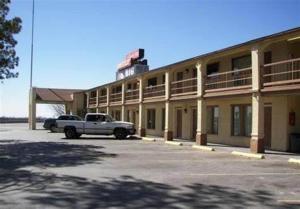 a white truck parked in front of a building at Quest Inn Weatherford in Weatherford