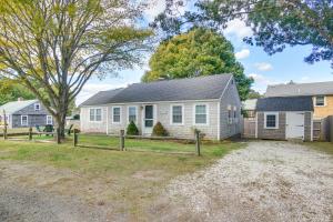 une maison blanche avec une clôture devant dans l'établissement Less Than 1 Mi to Beaches Classic Cape Cod Cottage, à Dennis Port