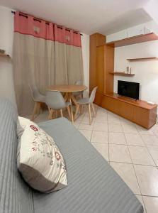 une chambre avec un lit et une table avec des chaises dans l'établissement Casa Rossa - Italian Style in Sestriere, à Sestrières