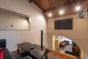 a living room with a couch and a tv on the wall at Cabana & La Chapelle - Proche Cluny et Tournus in Cortevaix