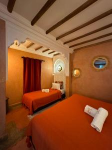 1 dormitorio con 2 camas naranjas en una habitación en Riad Andalla, en Marrakech