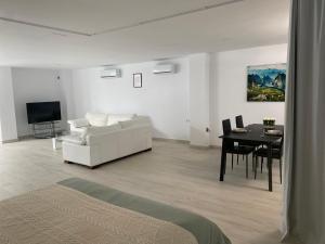 een woonkamer met een witte bank en een tafel bij New - MiJa basement Loft Apartment steps from Beach - perfect for Sun and Sport Seekers in Marbella