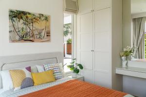 a bedroom with a bed with colorful pillows at Friendly Kamala Garden View in Kamala Beach +12 photos