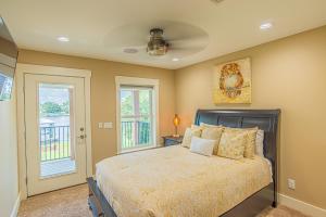 una camera da letto con un letto e due finestre di Dancin on the Waves On Lagoon Boat dock, Pool, Firepit a Panama City Beach Altre 34 foto