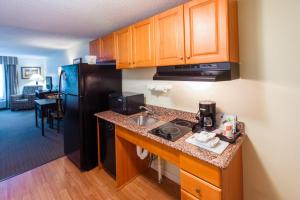 a kitchen with a sink and a black refrigerator at MainStay Suites Knoxville North I-75 in Knoxville