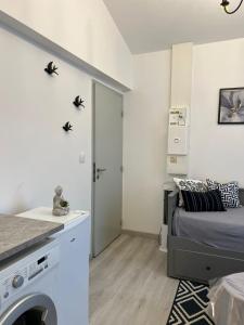 a small bedroom with a bed and a washing machine at Nouveau CDG Parc d'expo de Villepinte in Aulnay-sous-Bois