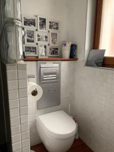 a small bathroom with a white toilet and photos at Morzine apartment, perfect ski and summer base for 8 in Montriond +14 photos
