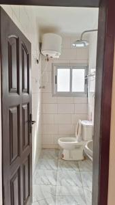 a bathroom with a toilet and a sink at Lumineux et cosy, entrée Bastos in Yaoundé