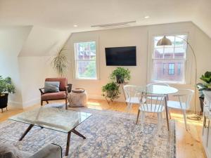 una sala de estar con una mesa y sillas en Spacious West End Loft in Charming Family Home, en Portland