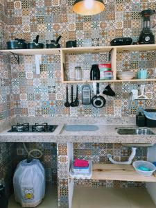 a tiled kitchen with a counter and a sink at Ilha de Boipeba kitnets para temporada - Morada dos Pássaros Boipeba in Ilha de Boipeba