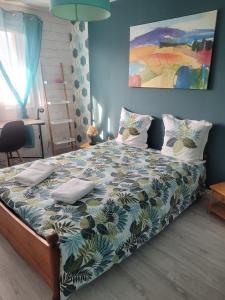 a bedroom with a large bed with a blue wall at Appartement proche Espace Anjou in Angers