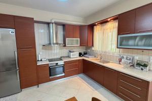 a kitchen with wooden cabinets and stainless steel appliances at Luxury Countryside House in Megála Kalývia