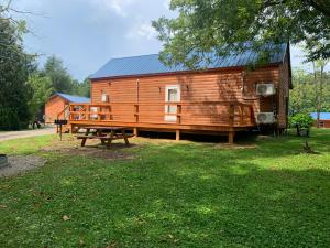 una baita di tronchi con tavolo da picnic e panca di Black House Mountain ATV Campground a Jamestown