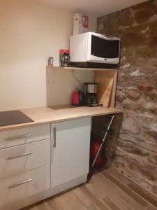 a kitchen with a microwave on top of a counter at La hautcsur la colline in Yzeron