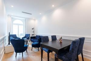 a dining room with a table and blue chairs at Boulevard Lisbon Bedrooms in Lisbon