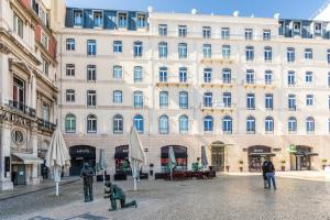 a large white building with people sitting in front of it at Boulevard Lisbon Bedrooms in Lisbon