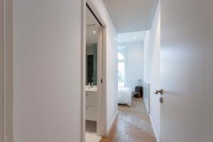 a white hallway with a mirror and a bedroom at Boulevard Lisbon Bedrooms in Lisbon +36 photos
