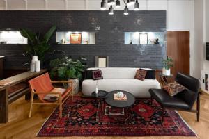 a living room with a white couch and a rug at FOUND Hotel, San Francisco in San Francisco