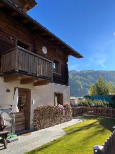 een houten huis met een balkon en een gazon bij Chalet Shany in Livigno