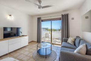 a living room with a couch and a tv at Costa Adeje Heated Pool Marina Primavera in Adeje