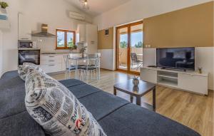 a living room with a blue couch and a kitchen at 4 Bedroom Cozy Home In Barbariga in Barbariga