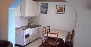a small kitchen with a table and a table and chairs at Vila Gorocvet in Sremska Kamenica
