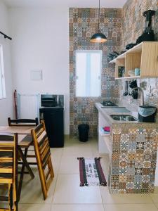 a kitchen with a table and a dining room at Ilha de Boipeba kitnets para temporada - Morada dos Pássaros Boipeba in Ilha de Boipeba +98 photos