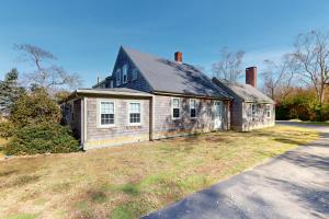 ein altes Backsteinhaus auf einem Hof in der Unterkunft Cape Landing Cottage in Brewster