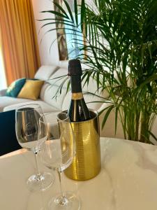 Boulevard Drobnera IV - Apartament nad Odrą - Rynek في فروتسواف: زجاجة من النبيذ موضوعة على طاولة مع كأسين من النبيذ