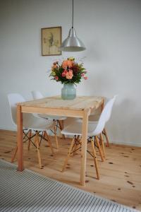 ein Esstisch mit einer Vase mit Blumen darauf in der Unterkunft Chiemsee Cottage in Prien am Chiemsee