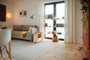 a living room with a couch and a window at Chiemsee Cottage in Prien am Chiemsee