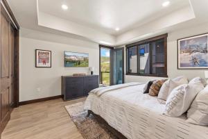 a bedroom with a large bed and a window at Heated Pool, Gourmet Kitchen, Pet Friendly, Gym, Walk to Canyons Village, 2 Private Patios in Park City