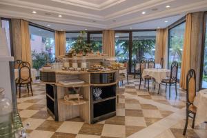 a dining room with tables and chairs and windows at Hotel President - Vintage Hotel in centro in Riccione