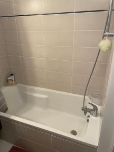 a bath tub with a shower in a bathroom at Chambre double privée in Annemasse