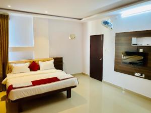 迈索尔Tulips Inn Mysuru的卧室里有一张床和一台电视机