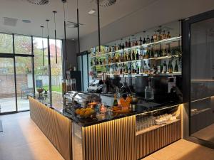 a bar with a counter with a lot of bottles at Tivoli Boutique Inn in Ljubljana