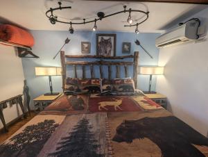 a bedroom with a bed with a cow blanket at Yellowstone Motel - Adults Only - All rooms have kitchens in West Yellowstone