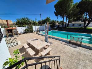 a pool with a bench and a table next to it at El Jardín de los Niños 2 in El Viso de San Juan