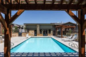 a swimming pool with a pergola next to a building at Room for 4, Modern Mountain Chic Interiors, Large Hot Tub, 5 Min Walk to Lift in Park City