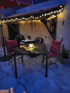 a patio with a table and chairs and lights at Studio à deux pas du village in Ceyreste