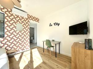 a living room with a table and a tv on a wall at Le City, Centre-ville, Climatisation, Trams in Grenoble