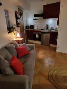 a living room with a couch and a kitchen at Studio à deux pas du village in Ceyreste