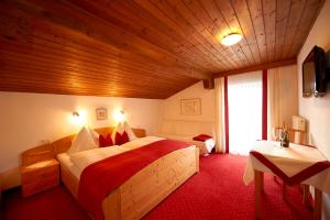 a bedroom with a large bed with a red carpet at Appartementhaus Gratz in Wagrain