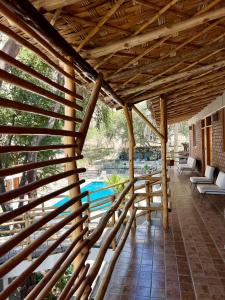 a wooden pergola with a pool in the background at Hotel El Huacachinero- Hotel Familiar in Ica