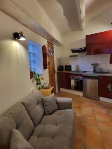 a living room with a couch and a kitchen at Studio à deux pas du village in Ceyreste +17 photos