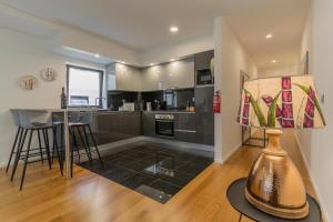 a kitchen and living room with a table and a lamp at Carreira Residence in Funchal